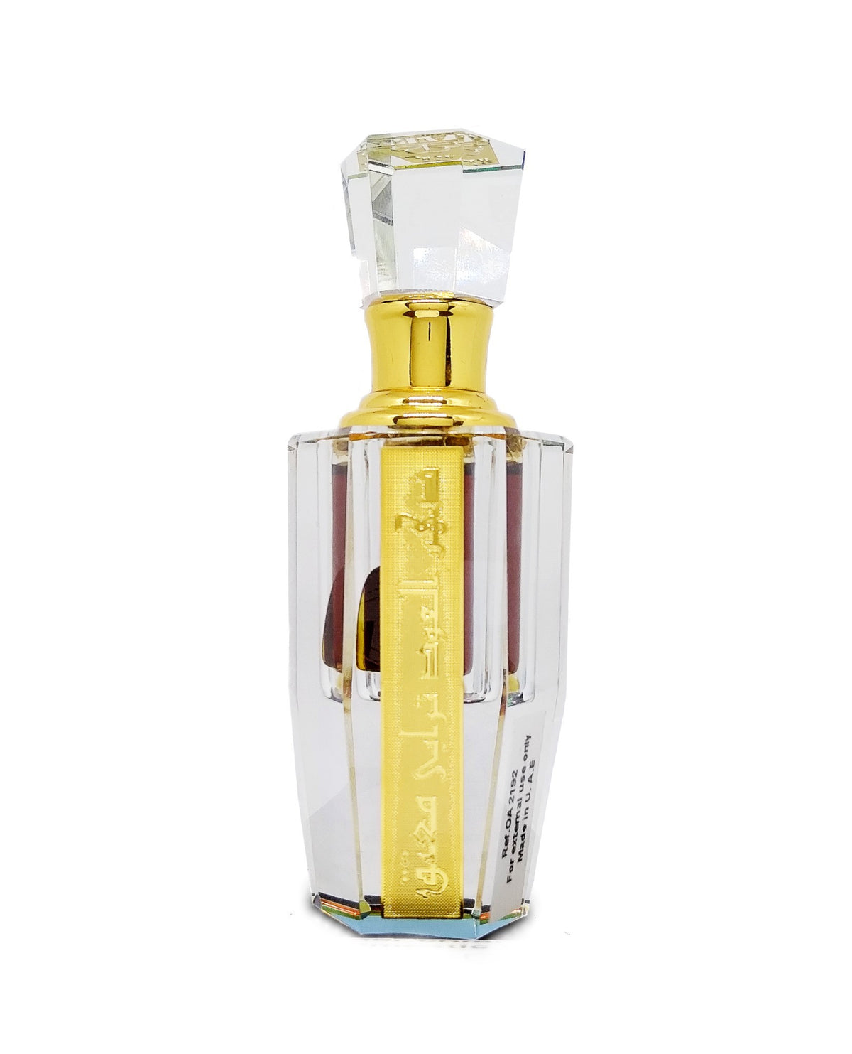 oud perfume Ornate clear glass perfume bottle with a gold cap and a vertical yellow label featuring gold Arabic script.