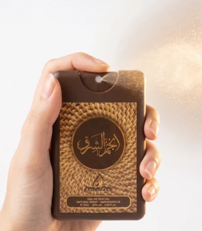 Hand spraying Anjam Al Sharq 20ml travel size pocket perfume, unisex oud fragrance by Ard Al Oud